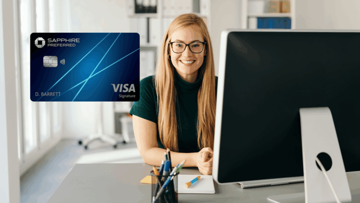 Mujer rubia con gafas sonriendo mientras trabaja en una oficina frente a su computadora. A la izquierda, se muestra una tarjeta Chase Sapphire Preferred Visa Signature de color azul.