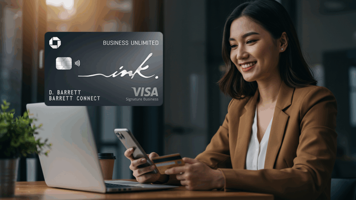 Mujer sonriente trabajando en una oficina moderna, sosteniendo una tarjeta de crédito mientras usa un teléfono móvil, con una tarjeta Chase Ink Business Unlimited visible en la parte superior izquierda.