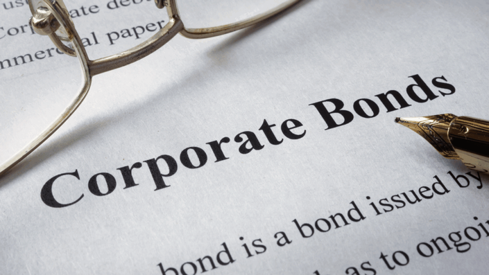 Documento con el título "Corporate Bonds" (Bonos Corporativos) en primer plano, con unas gafas y la punta de una pluma estilográfica dorada descansando sobre él, representando el análisis de los bonos.
