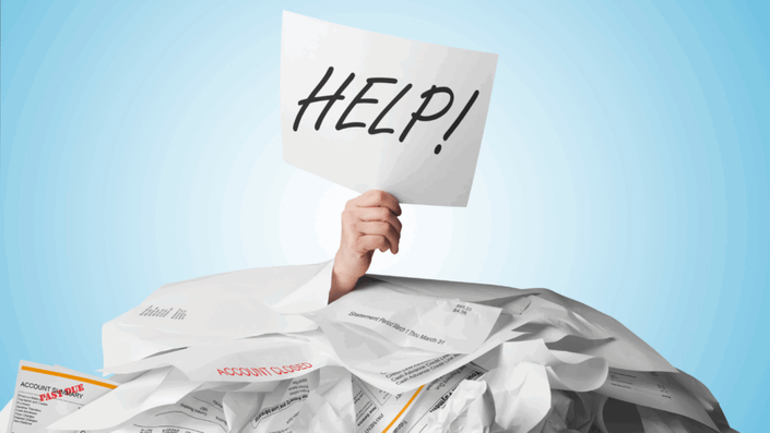 Mano sosteniendo un cartel de "HELP!" (¡AYUDA!) saliendo de una pila de facturas y papeles de cuentas, simbolizando la necesidad de estrategias como el método bola de nieve para superar el ahogo financiero.