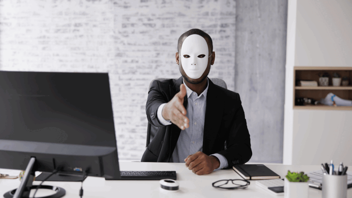 Hombre de negocios con una máscara blanca anónima extendiendo la mano para un apretón, simbolizando el engaño detrás de los fraudes financieros.