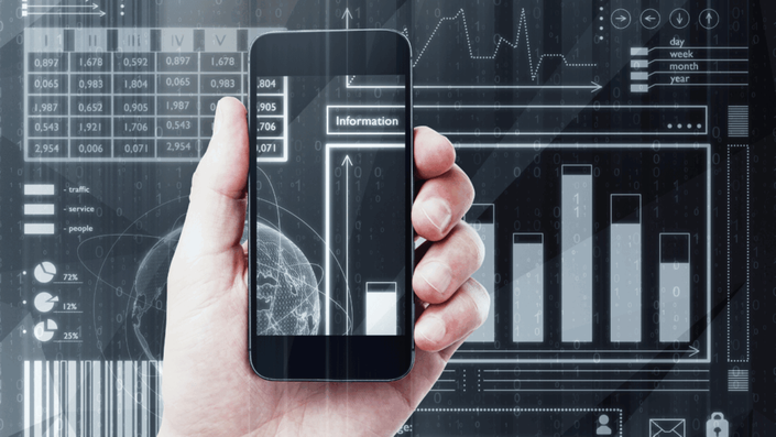 Mano sosteniendo un smartphone que muestra información y gráficos financieros, con un fondo digital lleno de datos y diagramas, representando el análisis y la tecnología de las fintechs.